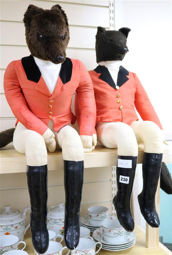 Two toy seated foxes in huntsman outfits